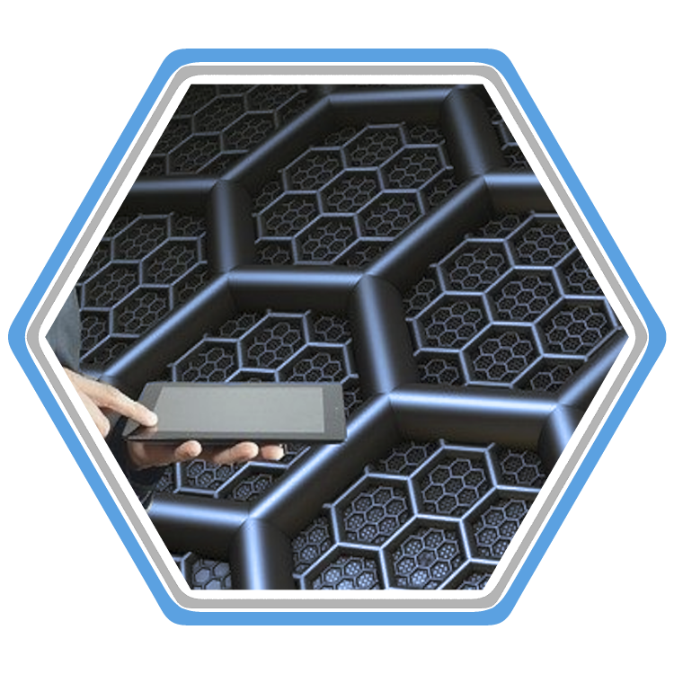 Tablet computer held in front of a futuristic metallic hexagon grid